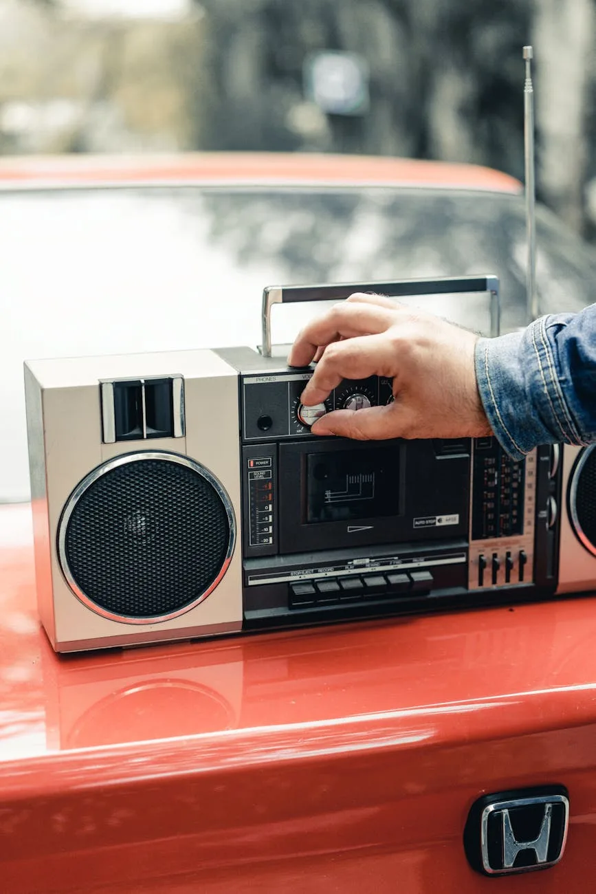 man turning on vintage boombox placed on red car