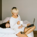 women in bed looking at a laptop